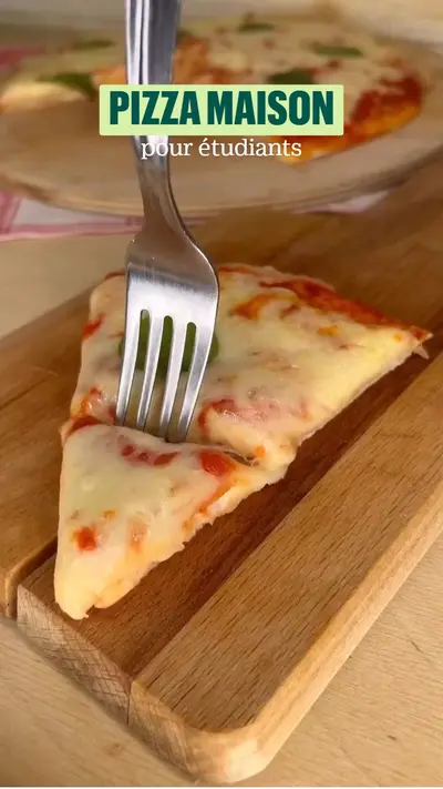 Une part de pizza au fromage fondante sur une planche en bois avec une fourchette plantée dedans.